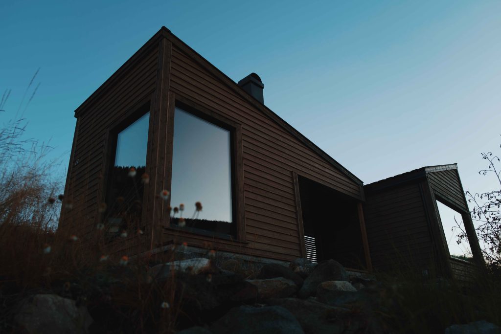 Badstovebygget sett utanfrå. Biletet er tatt på kvelden. Det er skumring.